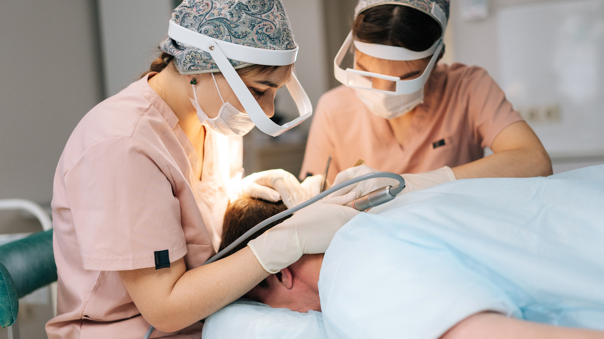 Two surgeons performing an FUE hair transplant in a modern Bogota clinic, Colombia.