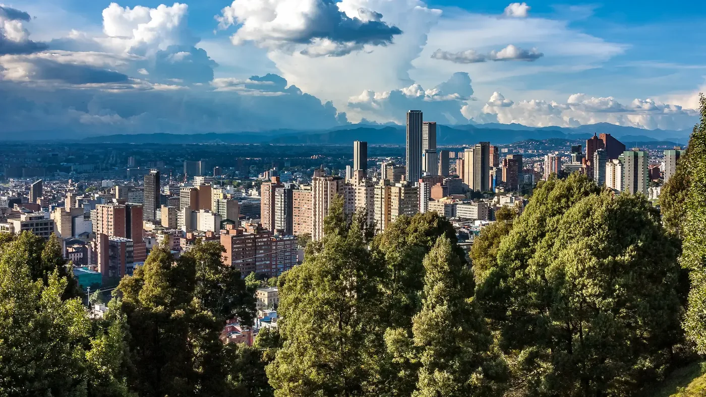 Medical district in Bogotá, Colombia with JCI-accredited facilities Panoramic view of Bogotá skyline with trees and dramatic clouds — Medical Tourism in Colombia